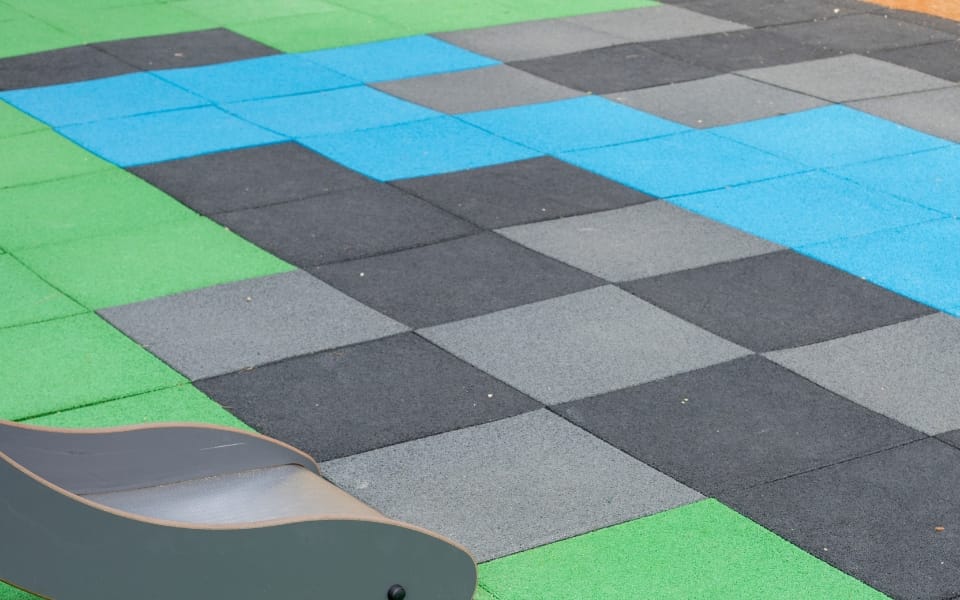 Close-up of a green, blue, grey and black EPDM tile pattern