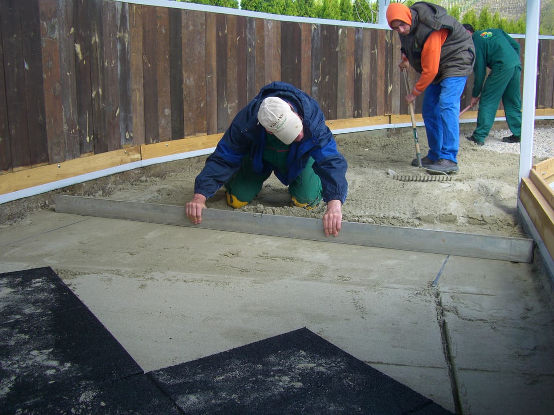 Rubber tiles being laid along the curve of the horse walker