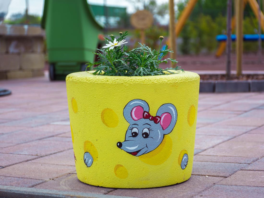 Yellow rubber planter painted with a mouse motif on the playground