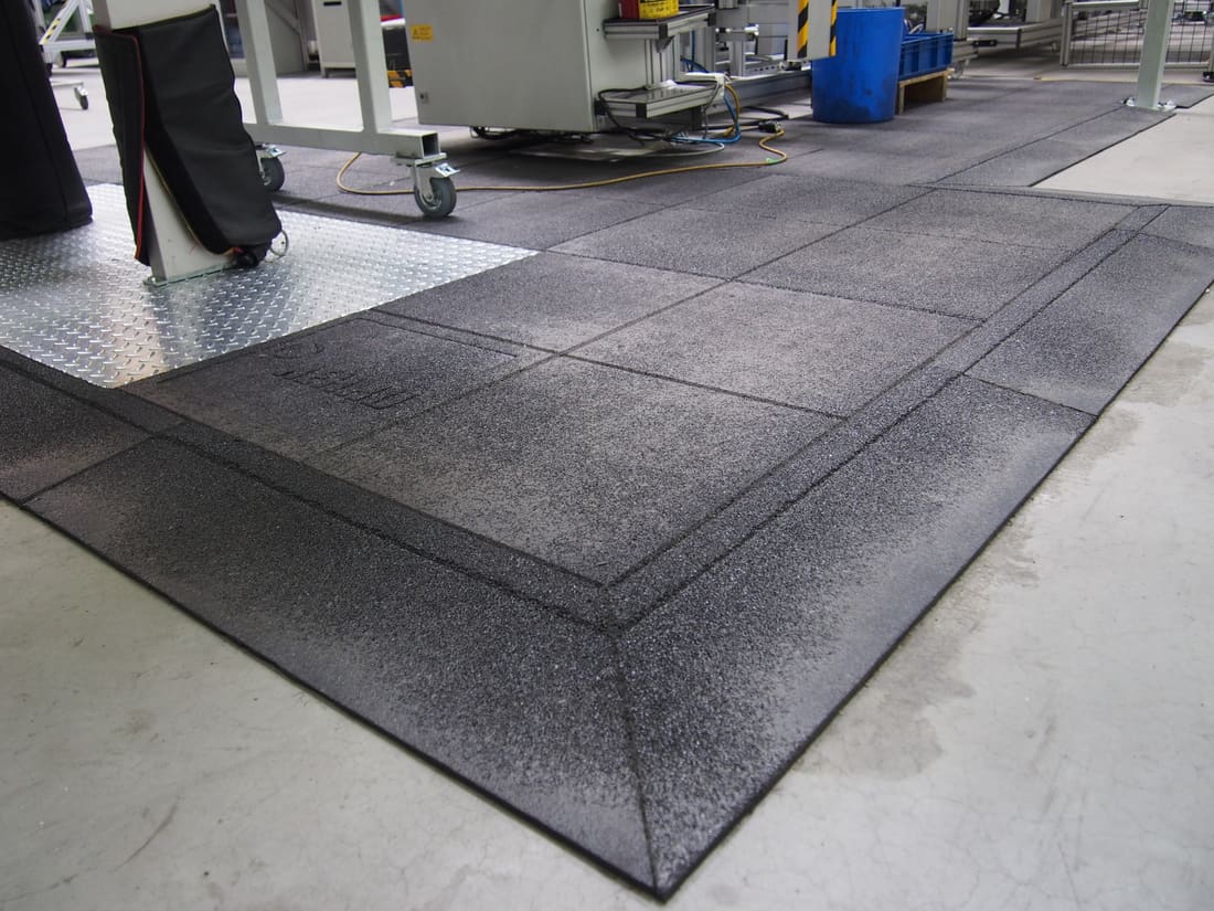 Bevelled edge of the rubber matting on a factory concrete floor
