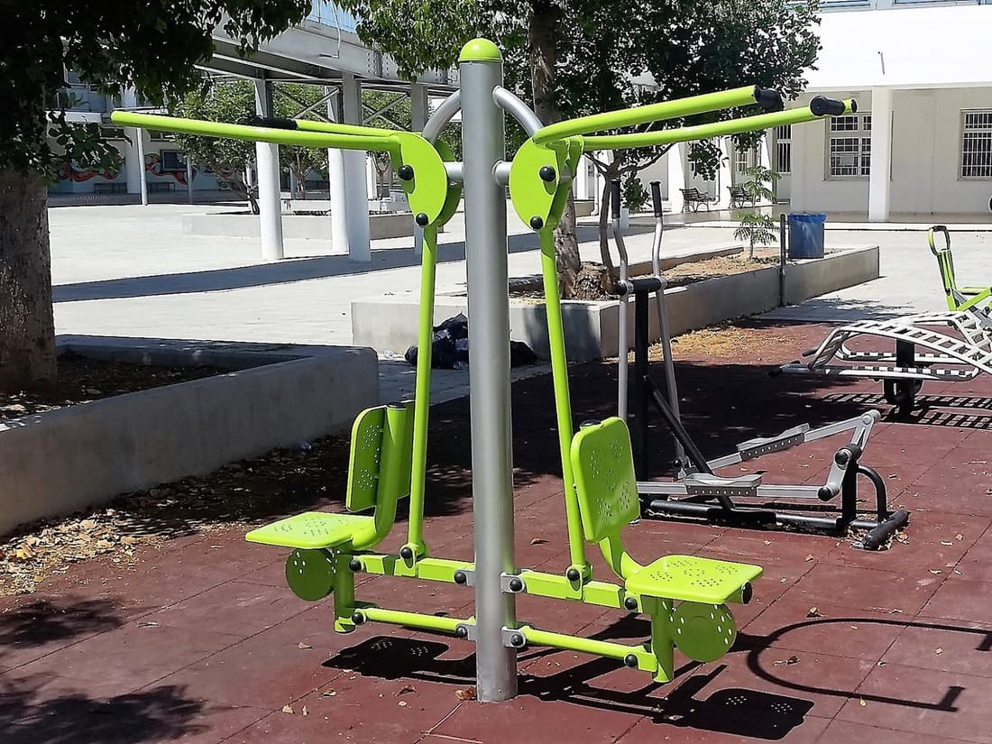 Outdoor fitness machines on red rubber tiles