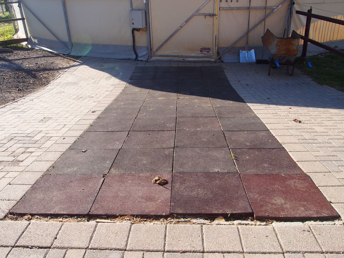 Red rubber tile surface in a covered equestrian facility
